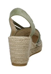 Sandal con zeppa verde in suede, con tacco in juta intrecciata, tomaia con motivo e cinturini incrociati. Il tacco misura circa 7 cm di altezza.