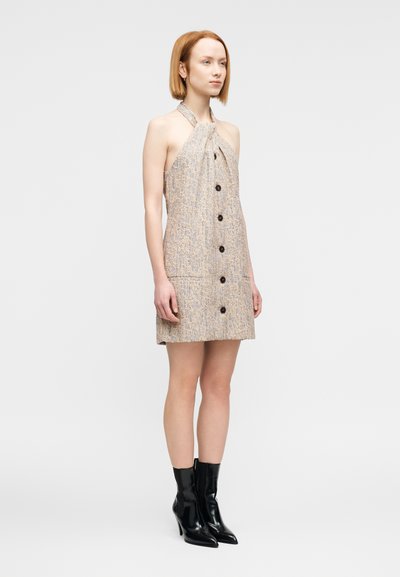 Φόρεμα με λαιμόκοψη halter από υφασμάτινη υφή σε μπεζ χρώμα με διακριτικό σχέδιο, με κουμπιά μπροστά, δύο τσέπες και ευθεία γραμμή; συνδυασμένο με μαύρα μποτάκια αστραγάλου.