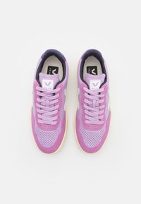 Sneaker viola con tomaia in pelle e suede, caratterizzate da dettagli perforati, lacci coordinati e accenti bianchi del logo. Suola in gomma resistente.