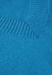 Maglione azzurro lavorato a maglia con scollo a costine e una texture liscia, con una leggera finitura lucida e dettagli di cucitura diagonale.
