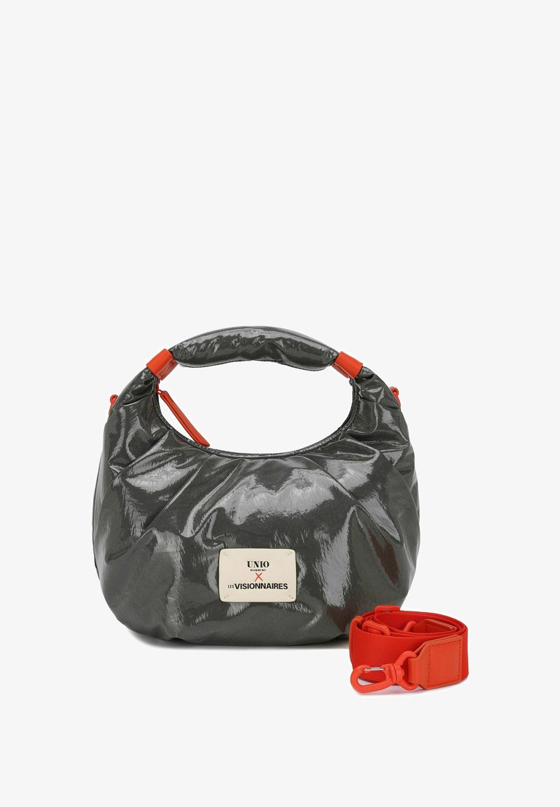 Bolso gris y brillante con forma redondeada, con detalles rojos y una correa desmontable. La etiqueta dice "UNIO x LES VISIONNAIRES".