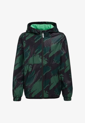 Kurtka wiatrówka w kamuflażu w ciemnozielonym i czarnym kolorze, z kapturem, zamkiem błyskawicznym z przodu i elastycznymi mankietami. Teksturowana tkanina z wzorem siateczki.