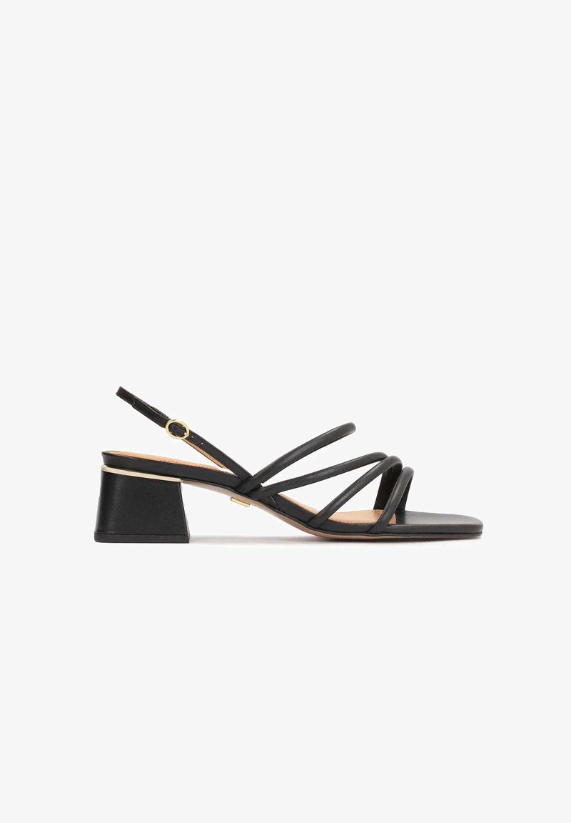 Sandale noire à fines brides, talon bloc bas, bride de cheville réglable avec boucle dorée et bout carré.