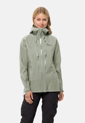 Hellgrüne wasserdichte Jacke mit Kapuze, ausgestattet mit zwei vorderen Reißverschlusstaschen und verstellbaren Bündchen. Logo auf der Brust. 