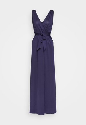 Robe maxi violette avec encolure en V, design sans manches, taille cintrée et détail de ceinture nouée. Tissu lisse avec une silhouette fluide.