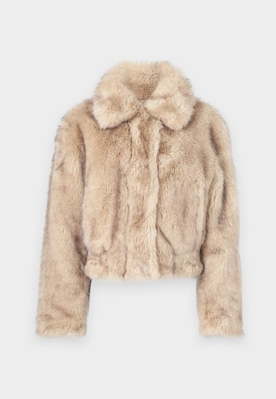 Šviesiai bežinė trumpa dirbtinio kailio striukė, su įpjovimu ant apykaklės, minkšta, pūkuota tekstūra, ilgomis rankovėmis ir aptemptu apvadu.