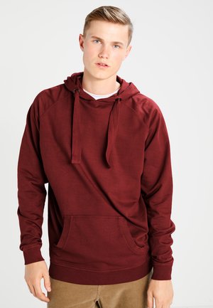 Maroon hoodie with a front kangaroo pocket, drawstring hood, and raglan sleeves; made from soft, textured fabric.