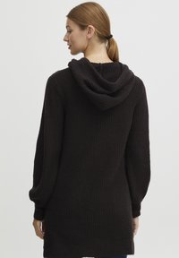 Mörkbrun ribbade hoodie med långa ärmar och en avslappnad passform. Har en mjuk textur och en rundad huva bak.