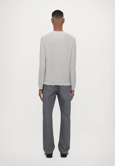 Graues Langarmshirt mit strukturiertem Muster, runden Ausschnitt und lässigem Schnitt, kombiniert mit dunkelgrauen geraden Jeans.