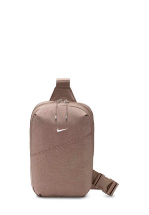 Mała brązowa torebka na ramię z regulowanym paskiem i podwójnym zamkiem błyskawicznym, z białym logo Nike w kształcie łyżwy z przodu.