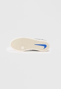 Juodas sportinis batų padas su šviesiai suformuota, į tekstūrą panašia guma ir mėlyna Nike swoosh logotipu. Zigzago raštas tamprumui.