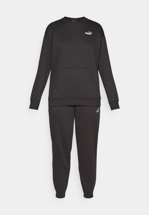 Crni pamukasti dukserica i hlače set. Okrugli izrez, dugi rukavi, prednji džep i elastični manžeti. Sadrži mali bijeli logo na prsima.