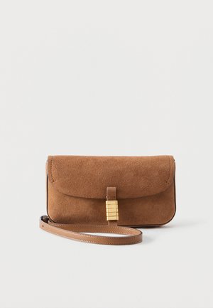 Brūna zamšādas plecu soma ar aizsegu, zelta tonēta aizdare un saskaņots ādas siksna uz balta fona.