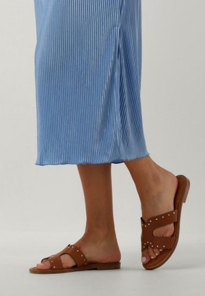 Lichtblauwe geribbelde midi-jurk met een zijsplit, gecombineerd met bruine platte sandalen met studaccenten en een gestructureerd bandontwerp.