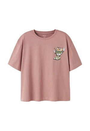 T-shirt rose poussiéreux à manches courtes avec un petit motif de crâne portant des lunettes de soleil, des baskets, et faisant des signes de la main rock clignotants sur le côté gauche de la poitrine.