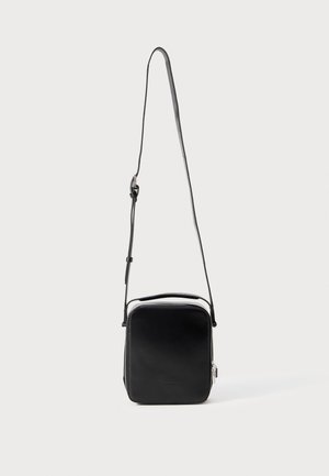 Borsa a tracolla in pelle nera con forma rettangolare, zip resistente e tracolla regolabile. Texture liscia e design minimalista.