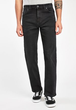 Svarta denimjeans med rak benpassform, som har framfickor, en metallknapp och vit sömnad. Tillsammans med svart och vita sneakers.