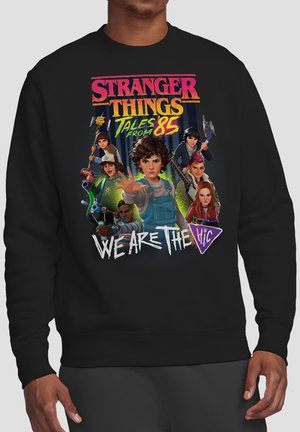 Group of seven animated kids with weapons from Stranger Things, with text "Stranger Things Tales from 85" and "We Are The H.I.C." on black sweatshirt.