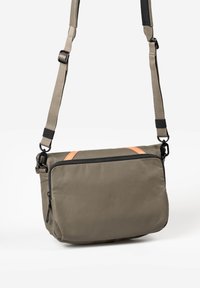 Borsa a tracolla khaki realizzata in un tessuto morbido e resistente, con una cerniera nera e un accento in pelle beige. Dotata di una tracolla regolabile e di una tasca laterale.