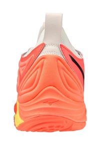Zapatilla deportiva con parte superior de malla coral y blanca, talón texturizado, acentos en negro y suela acolchada en naranja y amarillo.