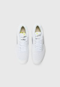 White athletic shoes with a textured upper, featuring a patterned design, lace closure, and yellow accent on the tongue.