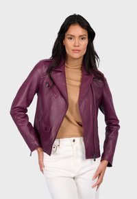 Bordeaux kožená motorkářská bunda s strukturovanými klopami, diagonální kapsou na zip, bočními kapsami a přiléhavým střihem. V kombinaci s béžovým rolákem.