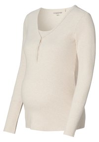 Beige zwangerschapsblouse met een V-hals, lange mouwen en een geribbelde textuur. Heeft een knoopsluiting en zijsplitten voor comfort en pasvorm.