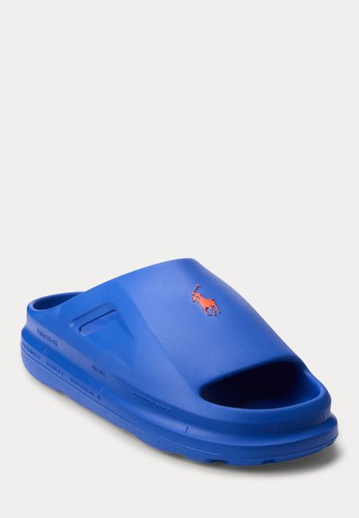Μπλε σανδάλι slide με ανοιχτό δάχτυλο και πορτοκαλί λογότυπο παίκτη πόλο στο πάνω μέρος.