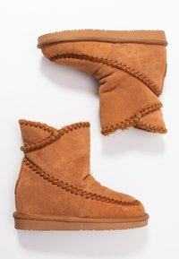 Bottines en daim beige avec des accents de couture tissée, texture douce et semelle en caoutchouc. Design décontracté avec un bout rond.