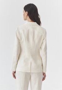 Aangepaste crème blazer met een gestructureerde pasvorm, met notch-revers en lange mouwen. De achterkant heeft een naaddetail en een kleine vent.