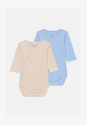 Két hosszúujjú bodysuit: az egyik bézs, a másik világoskék. Mindkettő átlapolt dizájnnal rendelkezik, nyomógombokkal záródik, és puha pamutból készült.