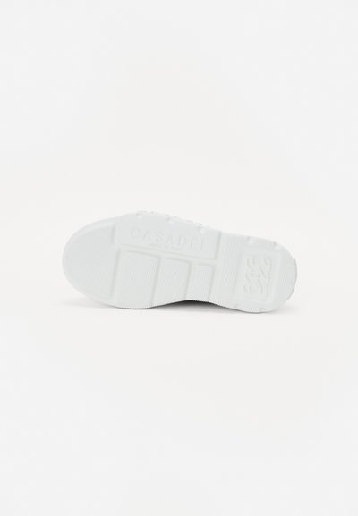 White rubber sneaker sole with textured grip, featuring ridges and logo detail. Minimalist design with smooth, clean lines and a flat profile.