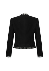 Veste noire longue à manches longues et courte en tissu texturé, avec des bords frangés sur le col, les poignets et l'ourlet, vue de dos sur un fond blanc.