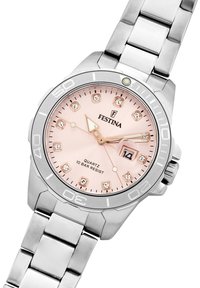 Festina kvarca pulkstenis ar sudraba nerūsējošā tērauda siksniņu un apaļu rozā ciparnīcu, kas aprīkota ar kristāla stundu rādītājiem un datuma displeju. Ūdens izturība līdz 10 bāriem.