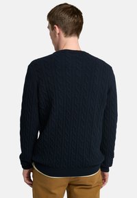 Maglione blu navy a maglia grossa con scollo rotondo, polsini e orlo a coste. Presenta un motivo testurizzato, maniche lunghe e vestibilità casual.