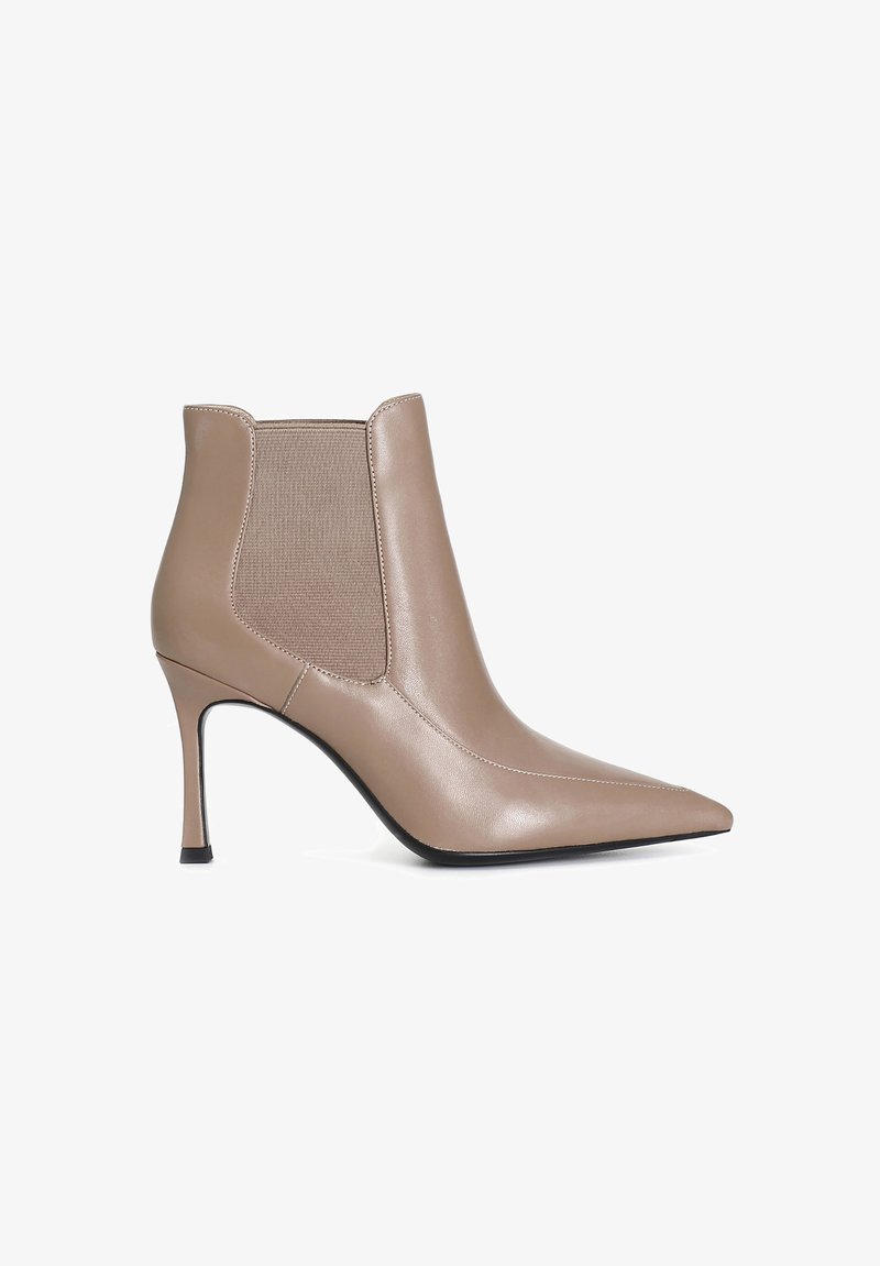 Béžová kožená kotníková bota s špičatou špičkou, elastickými bočními panely a tenkým vysokým podpatkem. Hladká textura a minimalistický design.