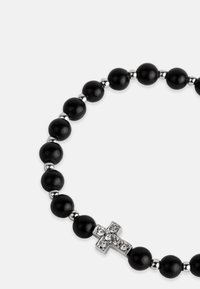 Brățară din mărgele negre cu separatoare din argint, având un accent de cruce împodobit cu strasuri. Textură netedă, formă rotundă și design simplu.