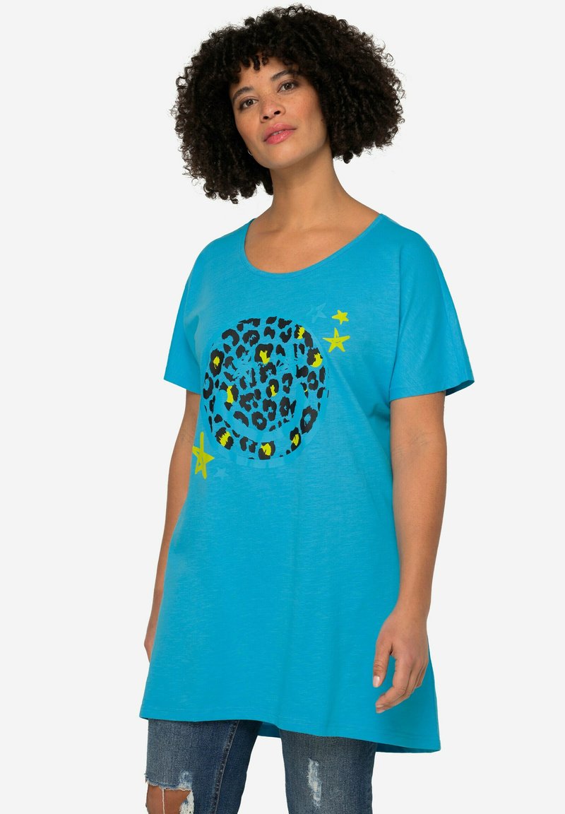 Camiseta de manga corta color turquesa con un gráfico circular de estampado de leopardo y estrellas amarillas. Fabricada con tela suave, presenta un corte relajado y un escote redondeado.
