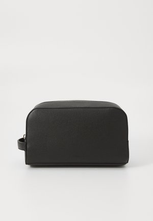 Sacola de higiene pessoal em couro preto, com formato retangular, superfície texturizada, fecho superior em zíper e uma alça lateral para facilitar o transporte.