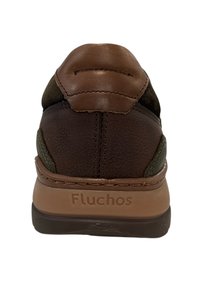 Bruine leren sneaker met bruine en groene accenten, gestructureerde achterkant, gevoerde kraag en logo op de hak. Rubberen zool voor grip.