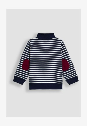 Námornícky a biely pruhovaný sveter s dlhým rukávom, stojacím golierom a červenými lakťovými náplasťami na oboch rukávoch.