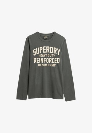 Langsleeve t-shirt van donkergrijze katoen, met bold crèmekleurige tekst: "SUPERDRY HEAVY DUTY REINFORCED DENIM COMP" over de voorkant.