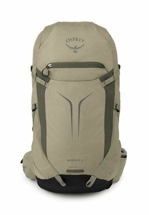 Sac à dos de randonnée Osprey Sportlite 30 beige et noir avec poche zippée devant, sangles latérales et poches rembourrées à la ceinture.