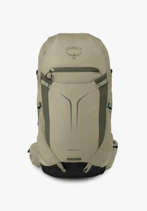 Sac à dos de randonnée Osprey Sportlite 30 beige et noir avec poche zippée devant, sangles latérales et poches rembourrées à la ceinture.