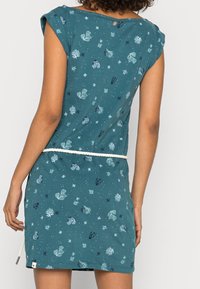 Turkusowa bawełniana sukienka z krótkimi rękawami, z nadrukiem przedstawiającym życie morskie. Pas ze sznurkiem akcentowany białym sznurkiem; detal z guzikami z tyłu.