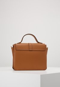 Borsa a mano in pelle marrone con finitura testurizzata, forma strutturata, manico superiore e chiusura a pattina. Caratterizzata da dettagli in metallo dorato.