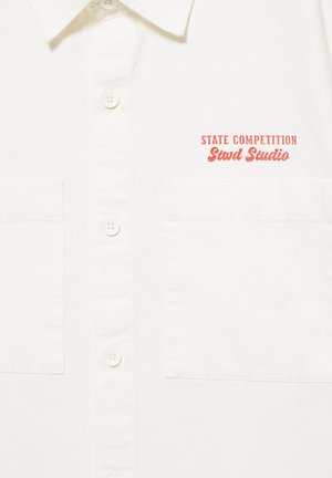 Biała koszula na guziki z dwoma przednimi kieszeniami i czerwonym tekstem „STATE COMPETITION Stwd Studio” po lewej stronie na wysokości klatki piersiowej.