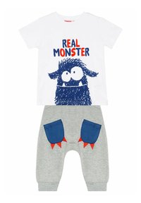 Weißes T-Shirt mit kurzen Ärmeln und blauer Monster-Grafik sowie dem Text "REAL MONSTER". Graue Hose mit blauen Taschen und roten Akzenten in Form von Stacheln.