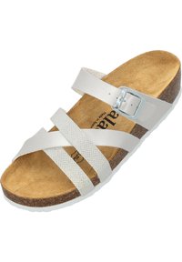 Bílé sandály se dvěma texturovanými pásky a stříbrnou sponou. Korková stélka s bledou podeševí. Vyšší design se zkříženými pásky.