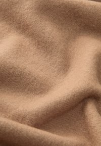 Tejido suave de color marrón claro con una textura lisa, que muestra un drapeado suave y fibras finas y sutiles. Adecuado para ropa y accesorios.